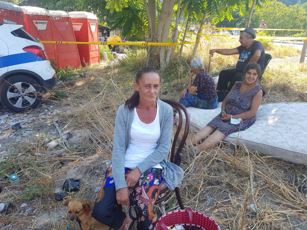 Alcuni occupanti del campo nomadi osservano le operazioni di sgombero