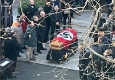 La bara esce avvolta da una svastica fuori dalla chiesa di Santa Lucia (foto da Facebook)