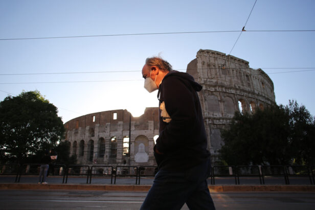 Un turista con mascherina davanti al Colosseo