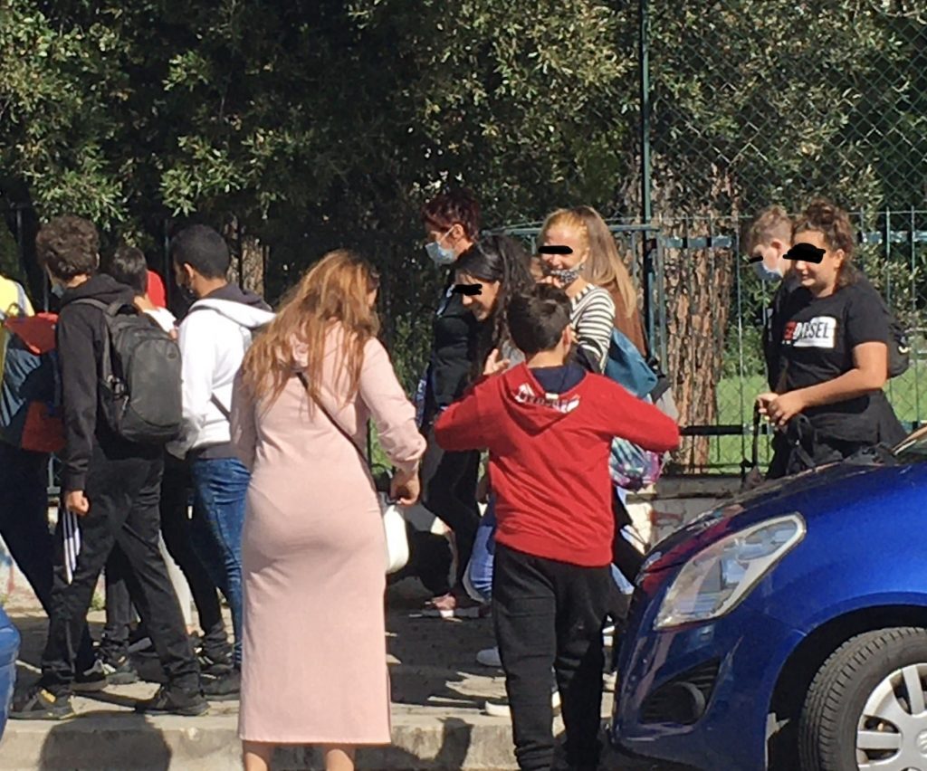 Un gruppo di ragazzi molto vicini tra loro e con la mascherina abbassata poco lontano dall'uscita dell'IC viale Adriatico