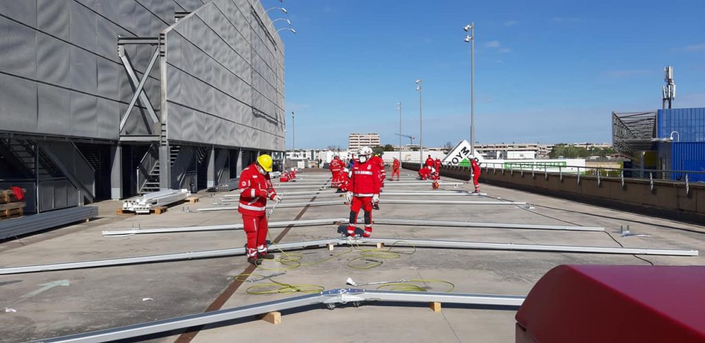 Volontari della Croce Rossa Italiana mentre costruiscono il centro vaccinale