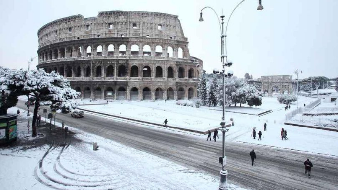 Via dei Fori Imperiali sotto la neve con lo sfondo dell'anfiteatro Flavio, il Colosseo, uno dei simboli di Roma. (Facebook: Cosa resterà degli anni '80)