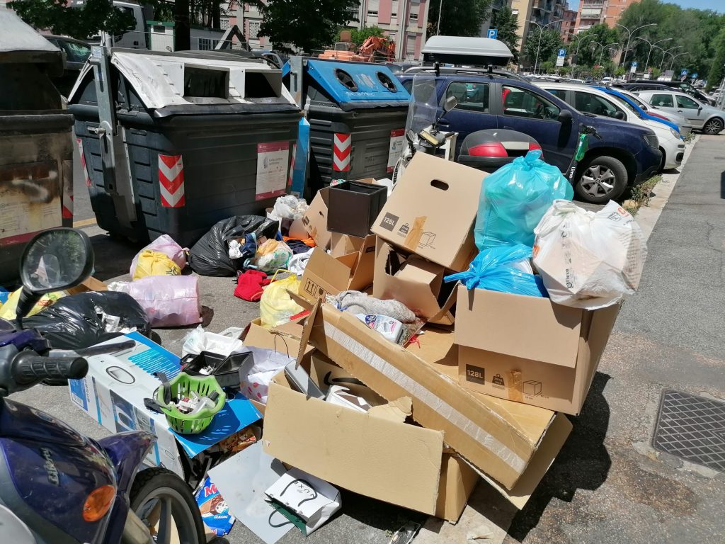 Scatoloni e sacchetti accumulati sul marciapiede in viale Etiopia