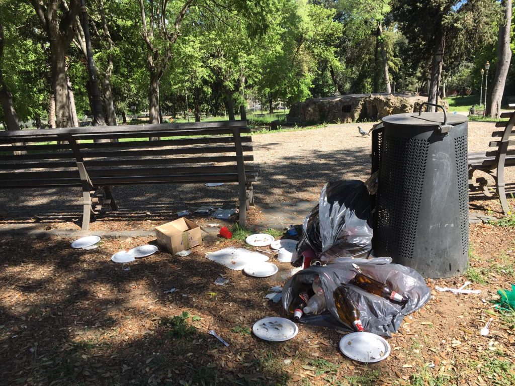 Sacchi di immondizia e piatti di plastica abbandonati a terra