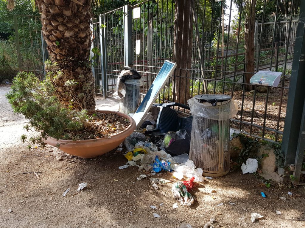 Cestini pieni e rifiuti a terra davanti all'ingresso di Villa Torlonia