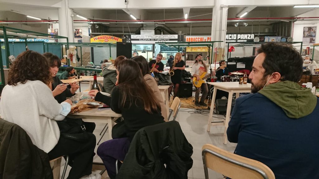 Il pubblico assiste all'esibizione de I Fleurs Du Mal al Mercato Trieste